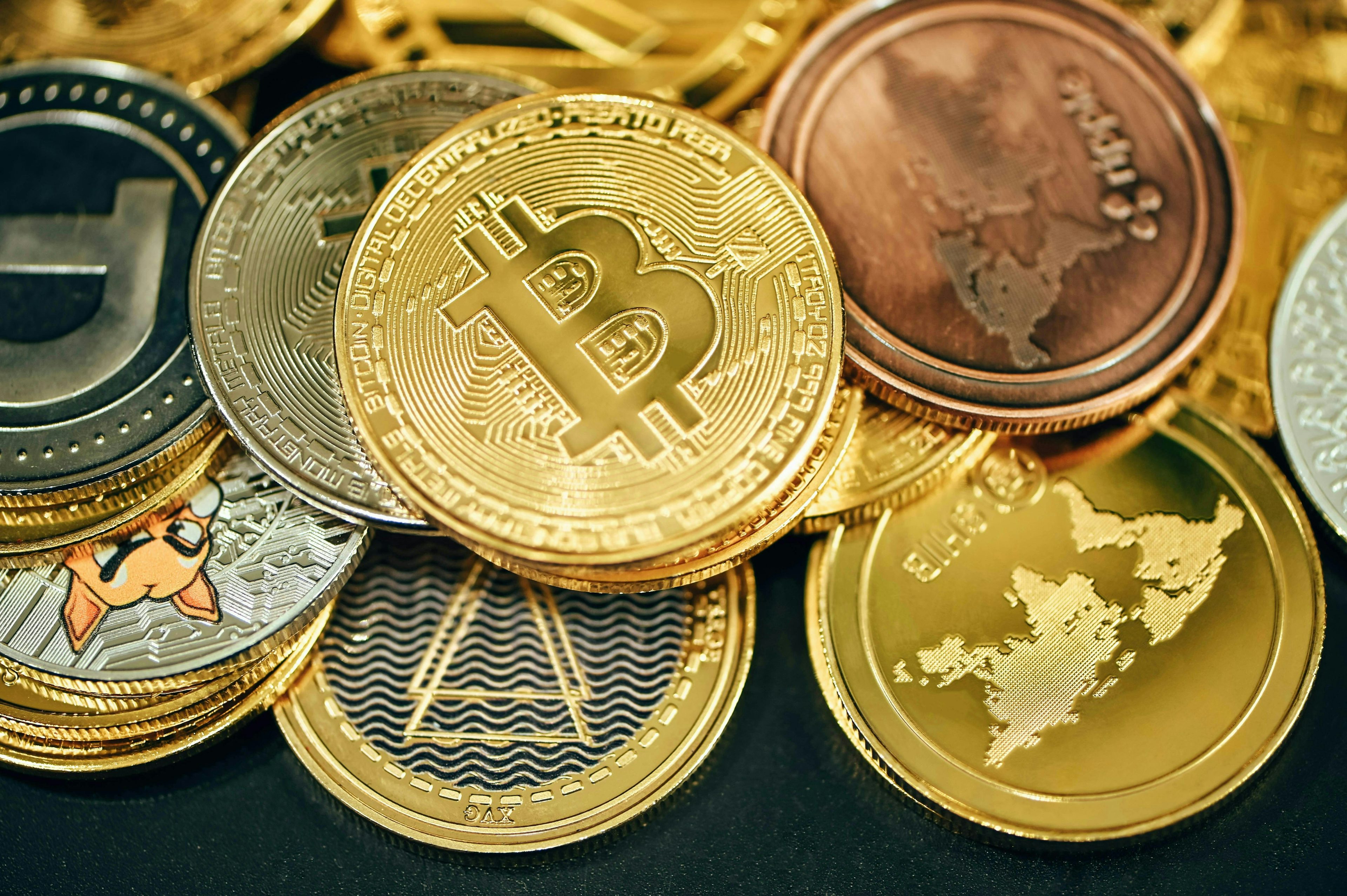 An image displaying an assortment of various cryptocurrency coins, each distinguished by unique symbols and designs representative of different digital currencies. The collection includes well-known coins such as Bitcoin, Ethereum, and Ripple, among others, arranged closely together to showcase the diversity within the cryptocurrency market.